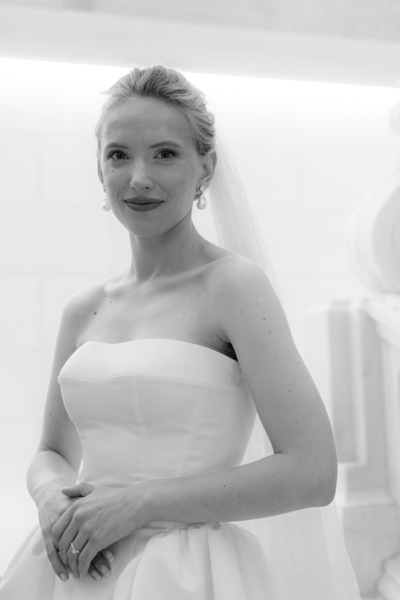 Black and white editorial portrait of a bride with pearl earrings and veil, wedding photographer in Austria