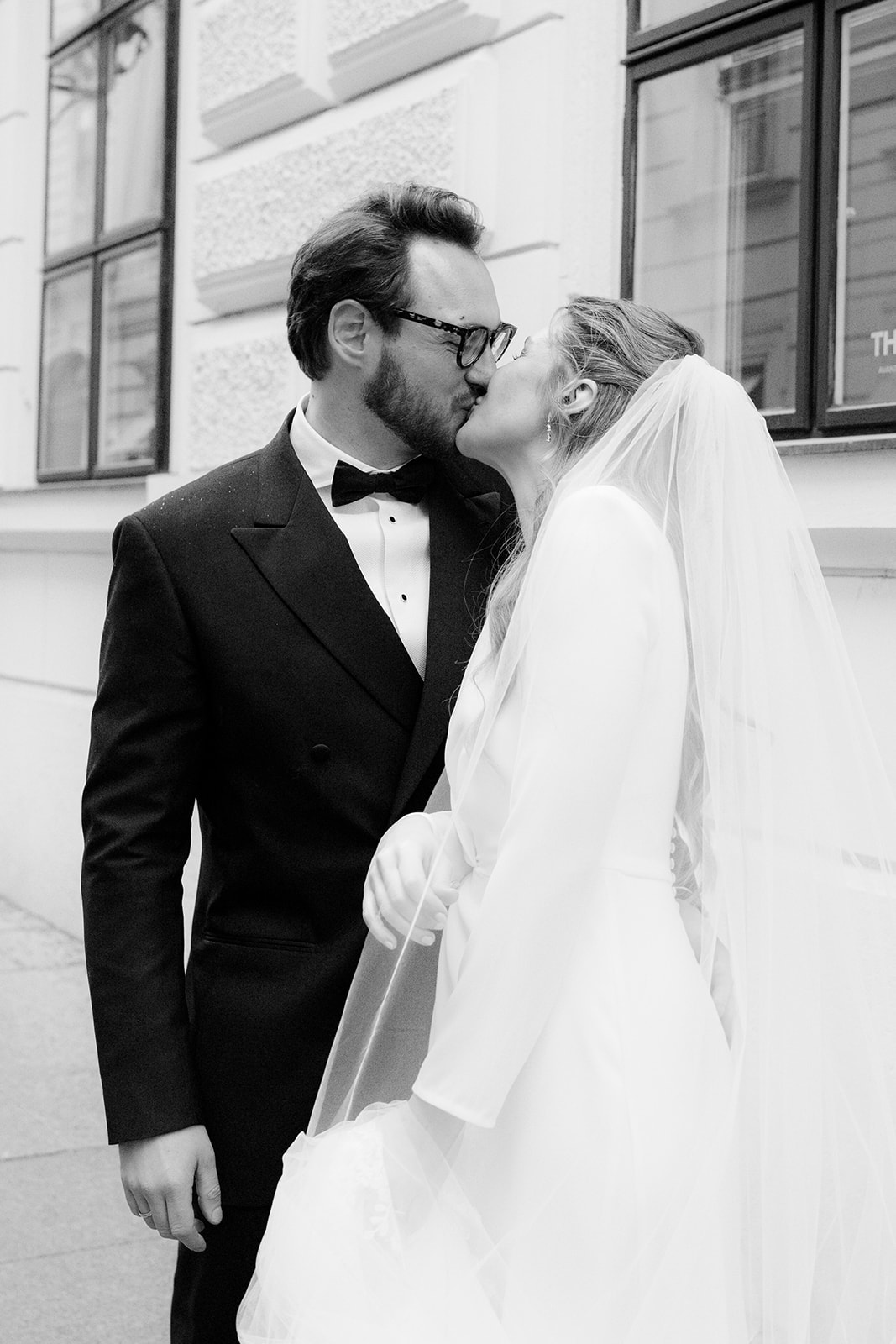 Black and white photo of bride and groom kissing on a street in Vienna's old town during a Park Hyatt Vienna wedding