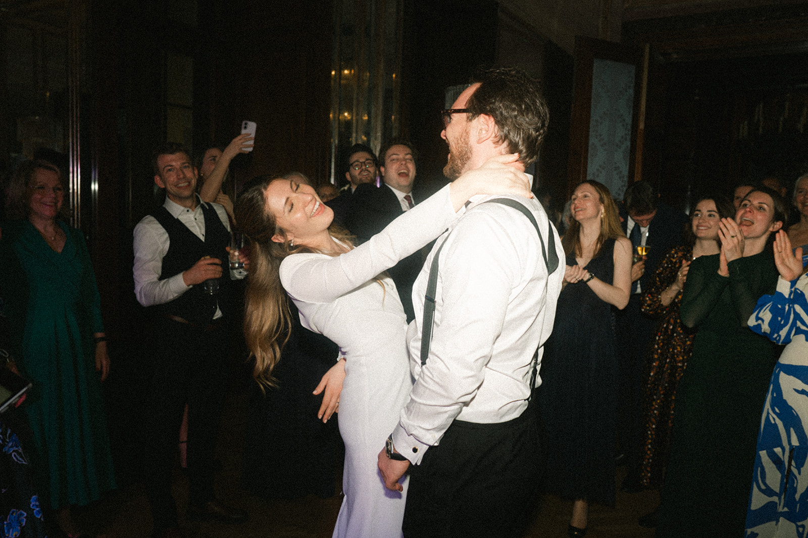 Bride and groom dancing and laughing among their guests at the wedding party at Park Hyatt Vienna