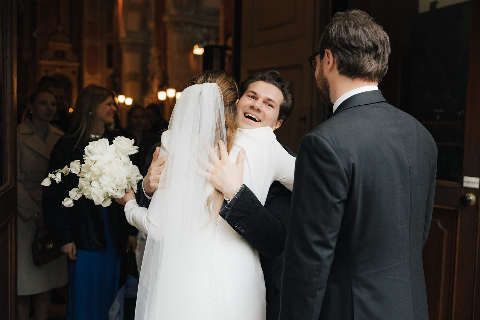 A guest hugging the bride after the ceremony at the church door, wedding in Vienna