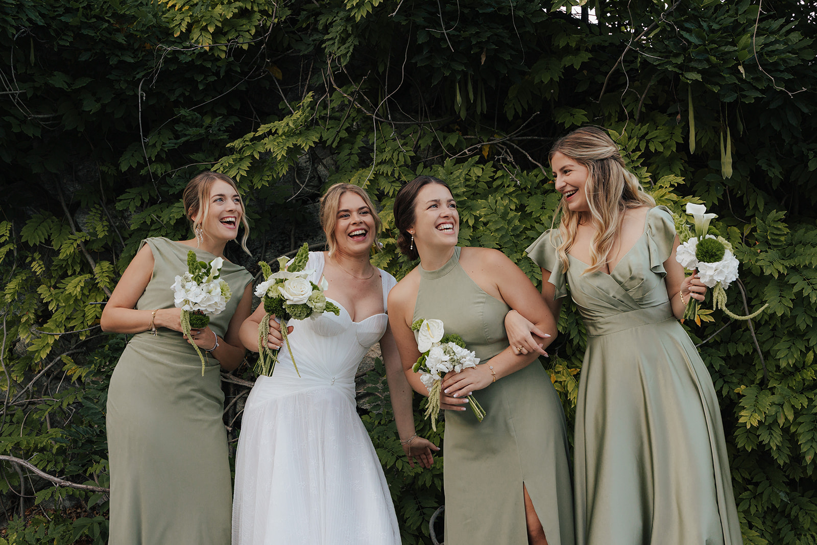 Bride laughing with her bridesmaids in sage green dresses at Refugium Hochstrass, Lower Austria