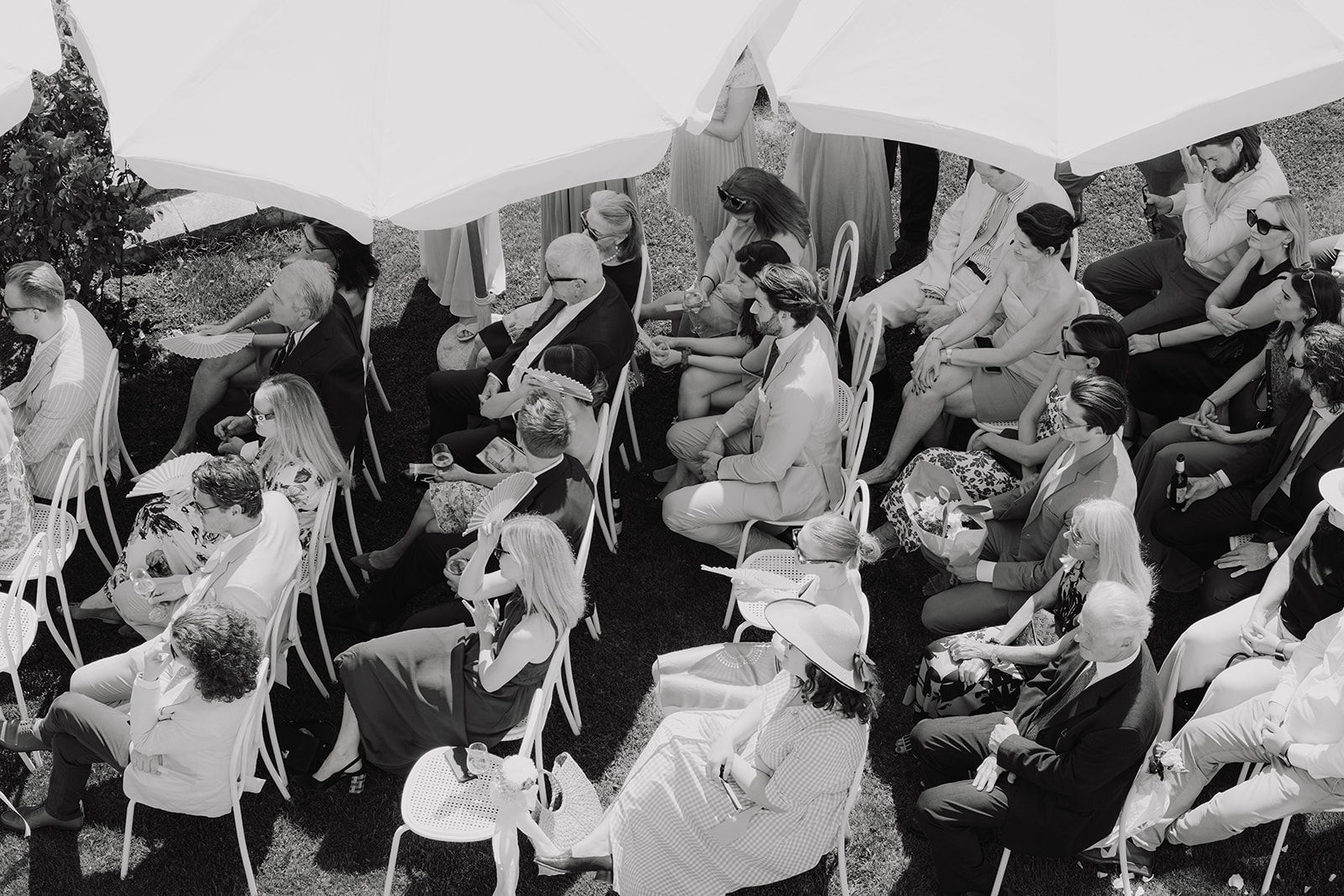 Black and white photo of wedding guests seen from above during the garden ceremony at Schloss Gobelsburg, Lower Austria