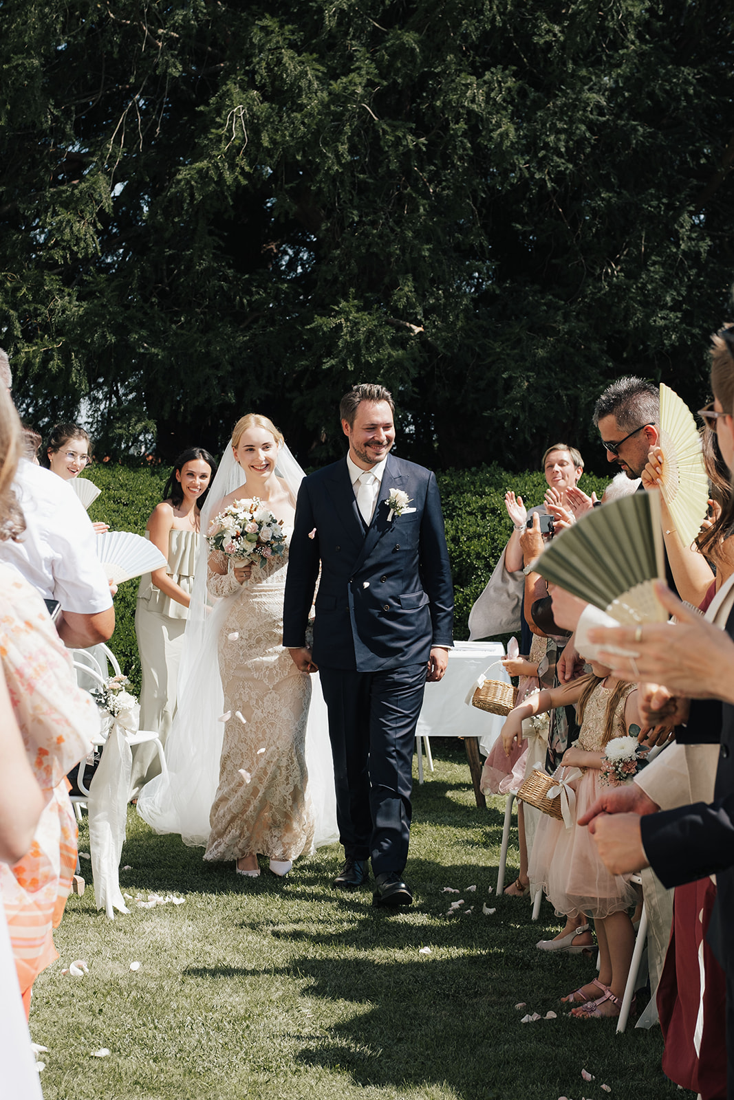 Bride and groom walking down the aisle after their garden ceremony at Schloss Gobelsburg in Lower Austria
