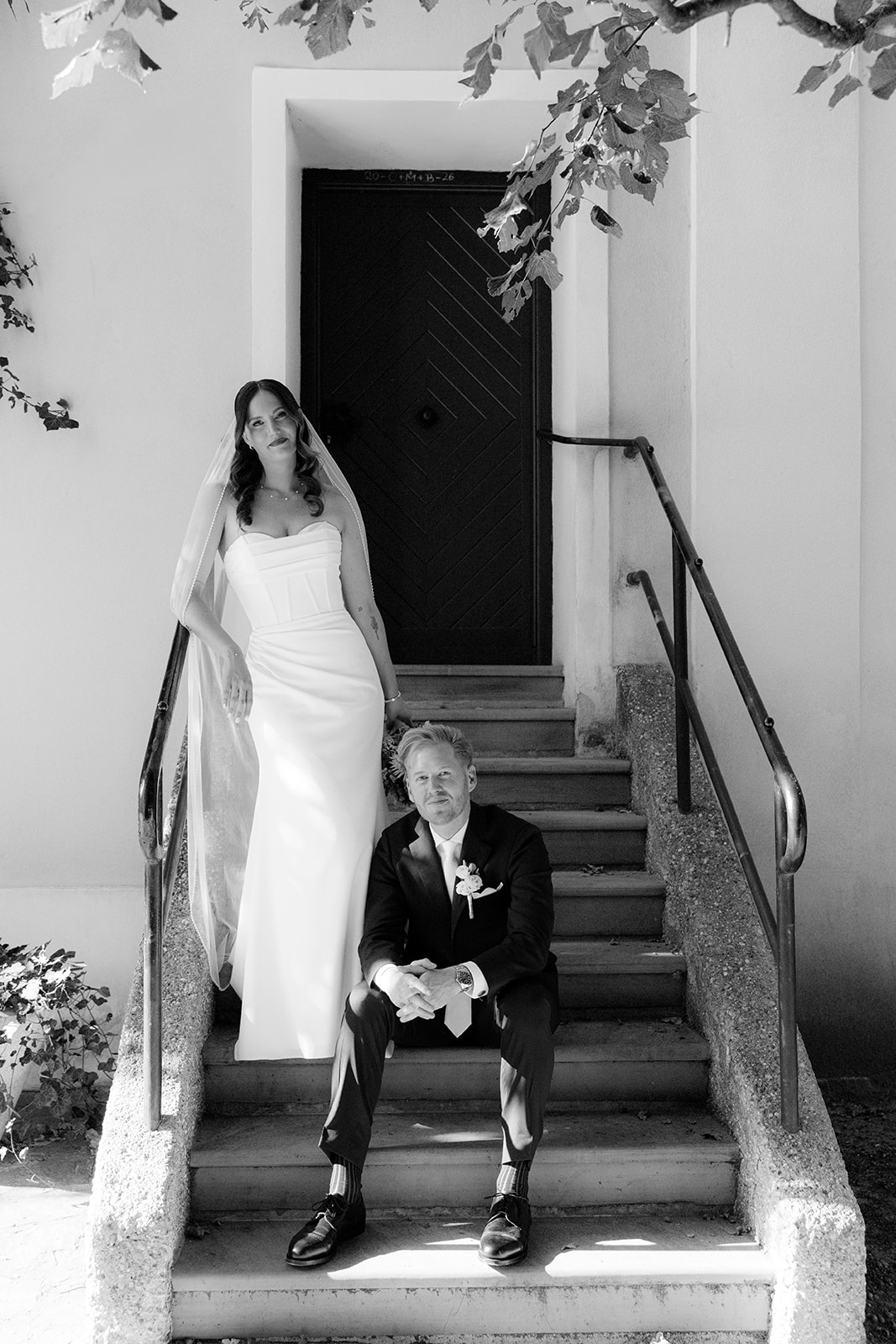 Black and white photo of bride and groom on the steps in front of a church door, wedding in Vienna